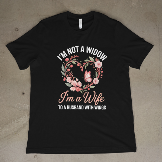 Black t-shirt with floral design and text on a concrete surface