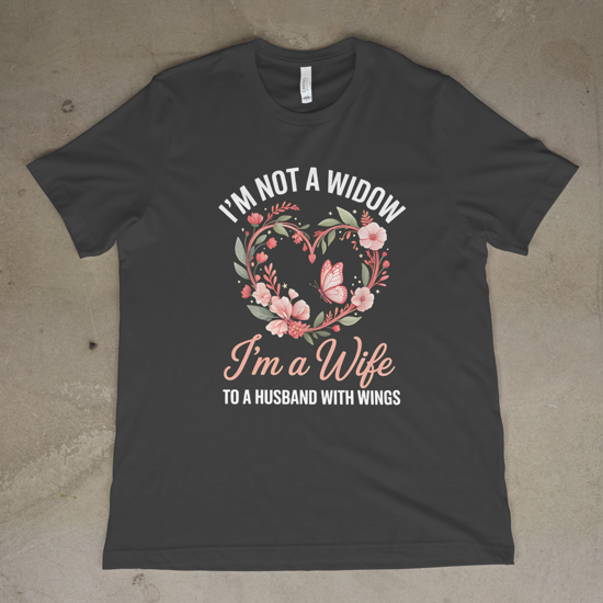 Dark gray t-shirt with floral design and text on a concrete floor.