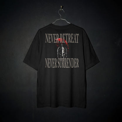 A black short-sleeve t-shirt hanging on a metal hanger against a dark textured background. The back of the shirt features a distressed graphic with the words 'NEVER RETREAT' and 'NEVER SURRENDER' in a light gray stencil font, surrounding a central Spartan helmet illustration with a red crest.