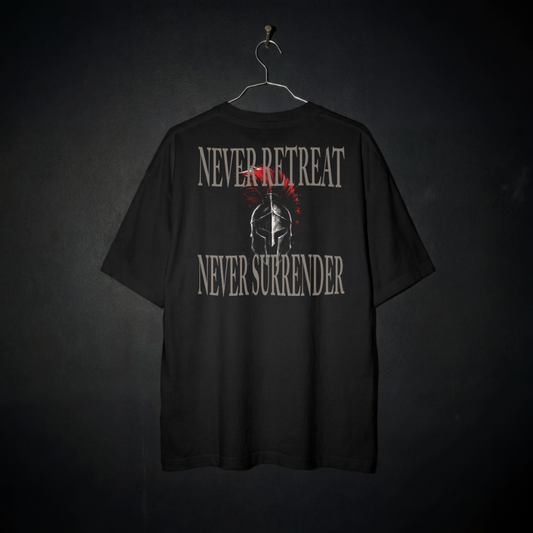 A black short-sleeve t-shirt hanging on a metal hanger against a dark textured background. The back of the shirt features a distressed graphic with the words 'NEVER RETREAT' and 'NEVER SURRENDER' in a light gray stencil font, surrounding a central Spartan helmet illustration with a red crest.