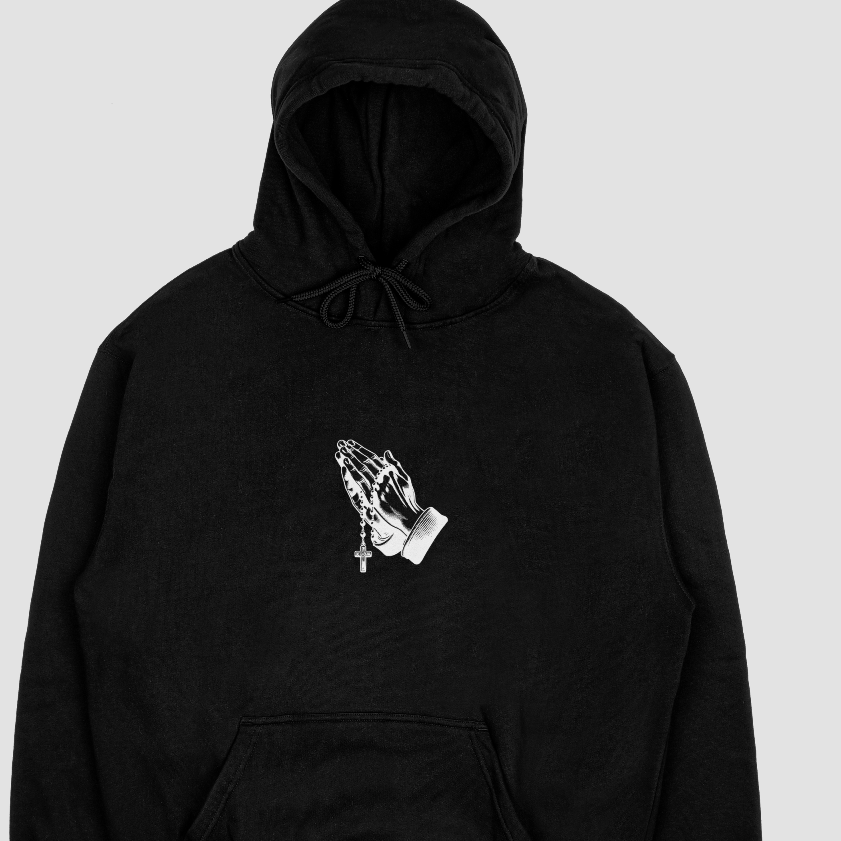 Black hoodie with a white praying hands design on a light gray background