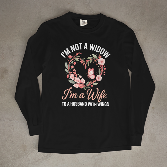 Black long-sleeve shirt with floral design and text on a concrete surface