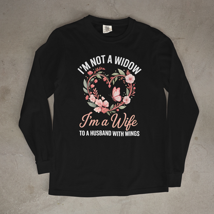 Black long-sleeve shirt with floral design and text on a concrete surface