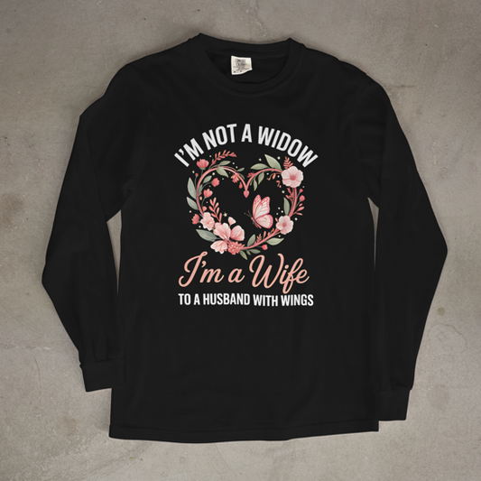 Black long-sleeve shirt with floral design and text on a concrete surface