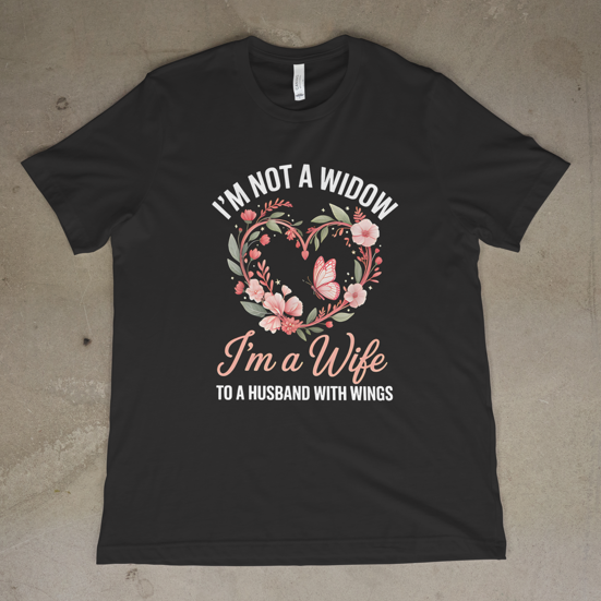 Black t-shirt with floral design and text on a concrete floor