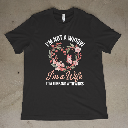 Black t-shirt with floral design and text on a concrete floor